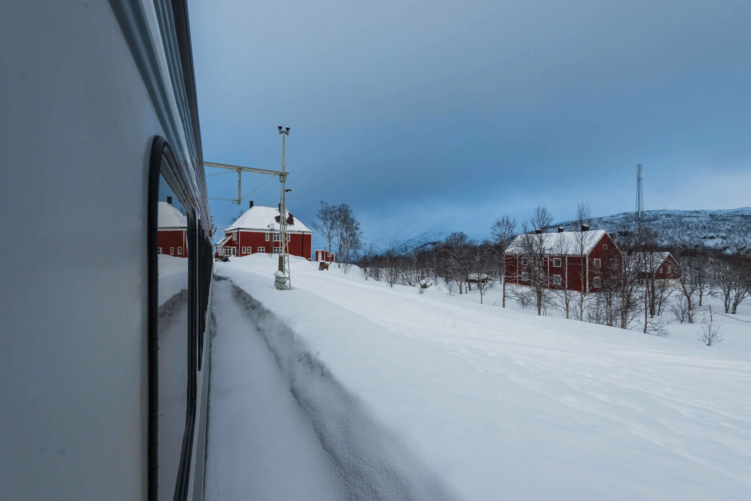 Udsigt fra nattoget over et snedækket landskab på vej mod Narvik